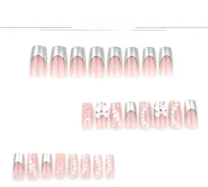 Detail of pink press-on nails with silver French tips and 3D bow accents