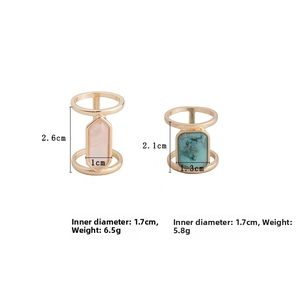 Detailed view of dual-ring gold bands with rectangular pink crystal and square turquoise stone
