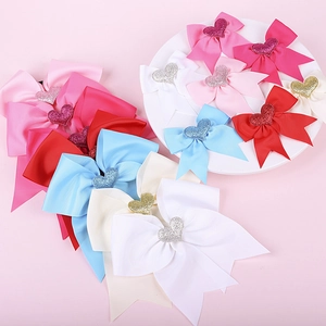 Macro shot of assorted colorful ribbon bow hair clips with glittery heart centerpieces