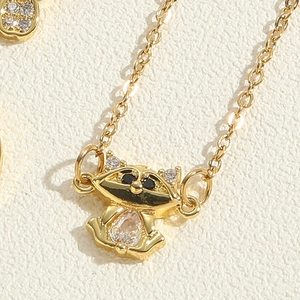 Macro detail of golden raccoon pendant necklace with sparkling zircon drop stone
