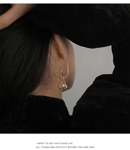 Details eines eleganten goldenen Tropfenohrrings mit Perle im französischen Vintage-Stil