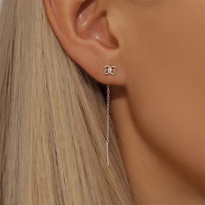 Close-up of a silver butterfly threader earring with a small crystal on a model's ear