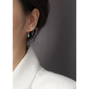Close-up of s925 silver fringe earrings with blue zircon crystals and chain details