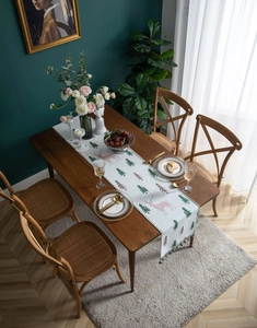 Detailed texture of white Christmas table runner with pink deer and green pine patterns