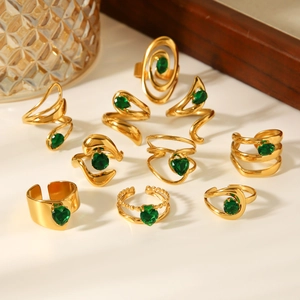 Detailed set of 10 gold stainless steel rings with green zircons and varied geometric designs