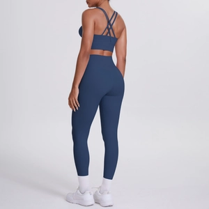 Dettaglio del set yoga blu navy con reggiseno sportivo incrociato e leggings a vita alta