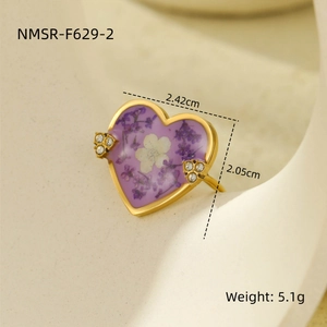 Detail of heart ring with purple dried flowers, white petals and rhinestones