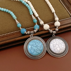 Close-up of bohemian round stone pendant necklaces with turquoise and white beads