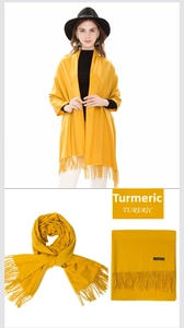 Detail of ginger yellow cashmere blend scarf featuring long fringe and soft texture