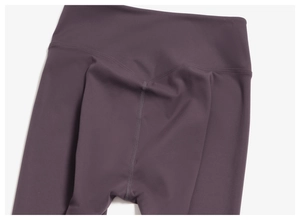 Détail du legging de yoga prune à taille haute avec coutures en V et finitions précises