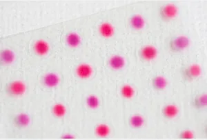 Macro view of 5D pink gradient nail stickers on transparent film with white textured background