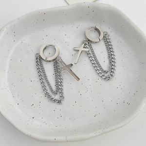 Silver stainless steel cross tassel earrings with double chains on a ceramic tray