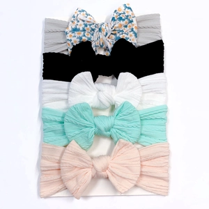 Detail showing 5-piece soft nylon baby headbands with ribbed bows on a display card