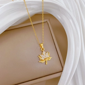 Macro shot of gold double-layer maple leaf necklace with sparkling rhinestones