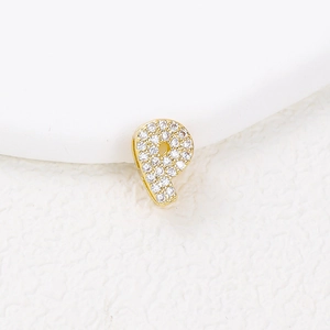 Macro shot of gold number 9 pendant with sparkling zircons on white background