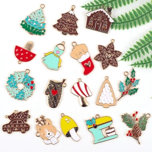 Flat lay of colorful Christmas enamel charms including gingerbread house and tree shapes