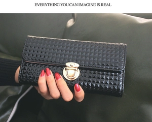 Détail de pochette noire pour femme avec motif géométrique 3D et boucle dorée