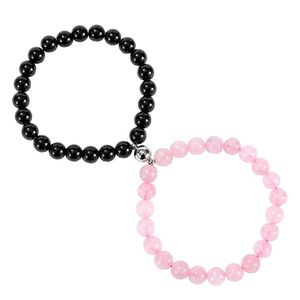 Detail of couple magnetic beads bracelets in black and pink with heart-shaped magnet charm