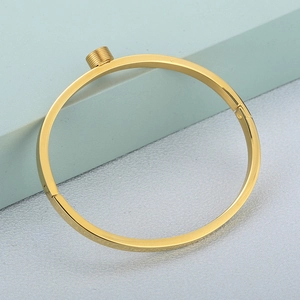 Bracciale rigido in acciaio inossidabile dorato con design a vite su sfondo geometrico