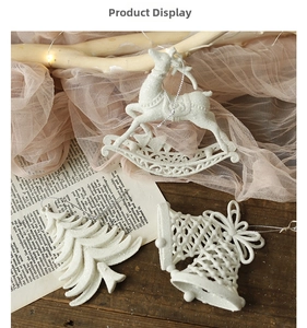 Close-up of white glitter Christmas ornaments including rocking horse and bell on wood
