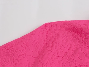 Close-up of pink fabric with embossed floral texture and high-quality 3D relief details