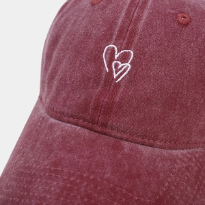 Close-up of heart embroidery on washed burgundy vintage style cotton baseball cap