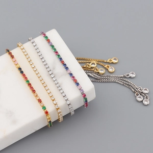 Detail of adjustable tennis bracelets with colorful zircons on a white marble display