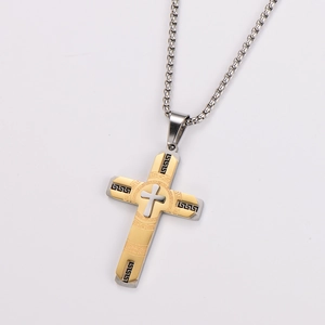 Close-up of dual-tone cross pendant with gold plating and black Greek key patterns