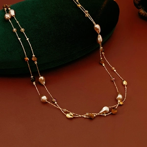 Dettaglio ravvicinato della collana a doppio strato con occhio di tigre e perle