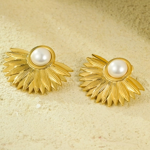 Vintage stainless steel fan-shaped earrings with pearls against a textured background