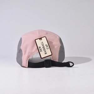 Detail of adjustable strap and tag on pink and grey nylon five-panel baseball cap
