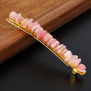 Macro shot of pink natural crystal stones hand-wrapped on a golden metal hair pin