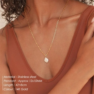 Close-up of 14K gold-plated paperclip chain necklace with baroque pearl pendant on model