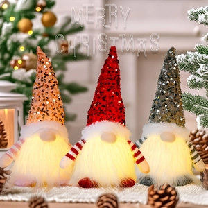 Close-up of three lighted Christmas gnomes with sequined hats and glowing beards