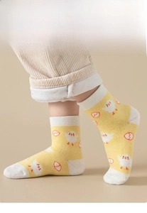 Detail of yellow cotton baby mid-tube socks with cute chicken patterns and white toe caps