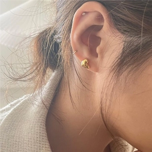 Minimalist 925 sterling silver gold heart stud earrings shown on model profile