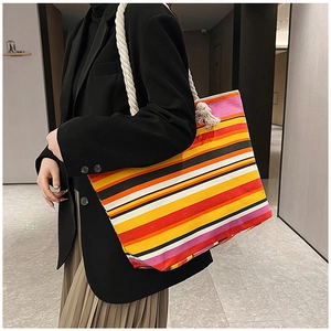 Rainbow striped canvas tote bag with thick hemp rope handles styled with a black blazer