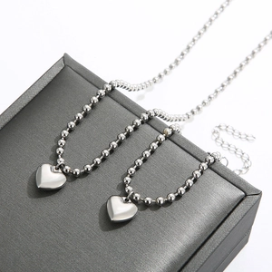 Gros plan de pendentifs cœur en argent sur chaînes à billes sur un coffret à bijoux