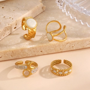 Set of four gold stainless steel rings with hammer texture and white enamel details