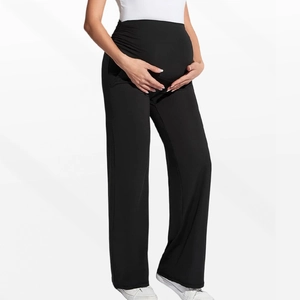 Detail of high-waist maternity support band on black stretch straight-leg pants