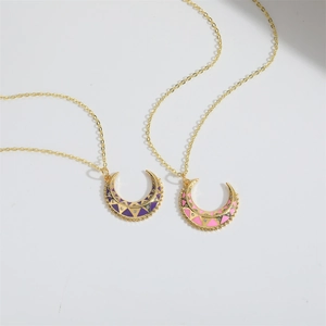 Detailed view of crescent moon pendants in purple and pink enamel on gold chains