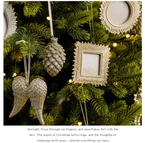 Golden glitter pine cones and winged ornaments hanging on a festive Christmas tree