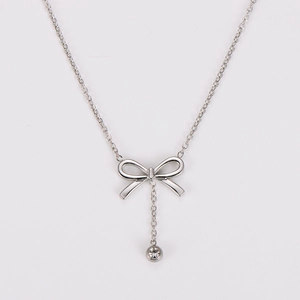 Detailed close-up of a silver bow necklace featuring a sparkling round diamond pendant