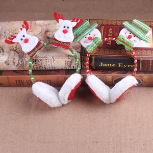 Detailed plush earmuffs featuring festive reindeer and snowman designs on vintage books