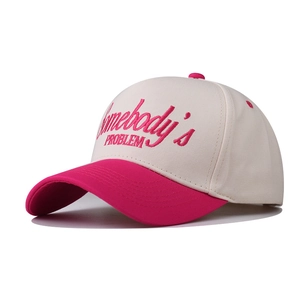 Détail de la broderie Somebody's Problem sur casquette en coton avec visière rose