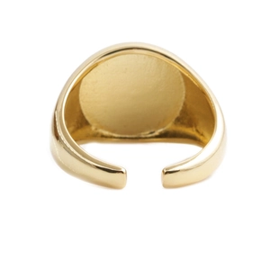 Bague ouverte ovale dorée minimaliste avec texture métallique polie sur fond blanc épuré