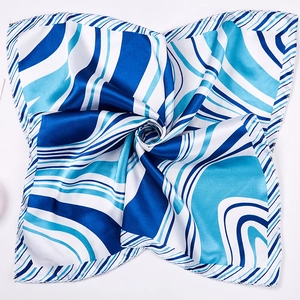 Detail of blue and white geometric striped silk scarf showing glossy satin fabric texture