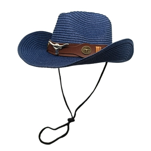 Detail of blue straw cowboy hat with brown leather band and metallic bull head ornament