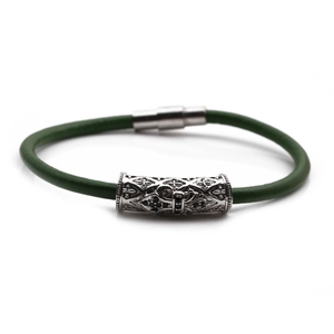 Detailed view of dark green braided leather bracelet with silver magnetic cross clasp