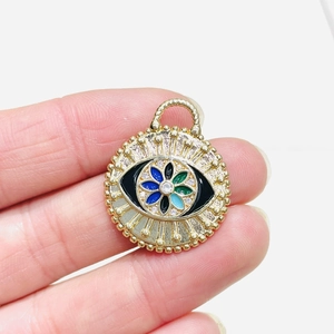 Detail shot of a gold-plated Evil Eye pendant with colorful enamel and zircon accents